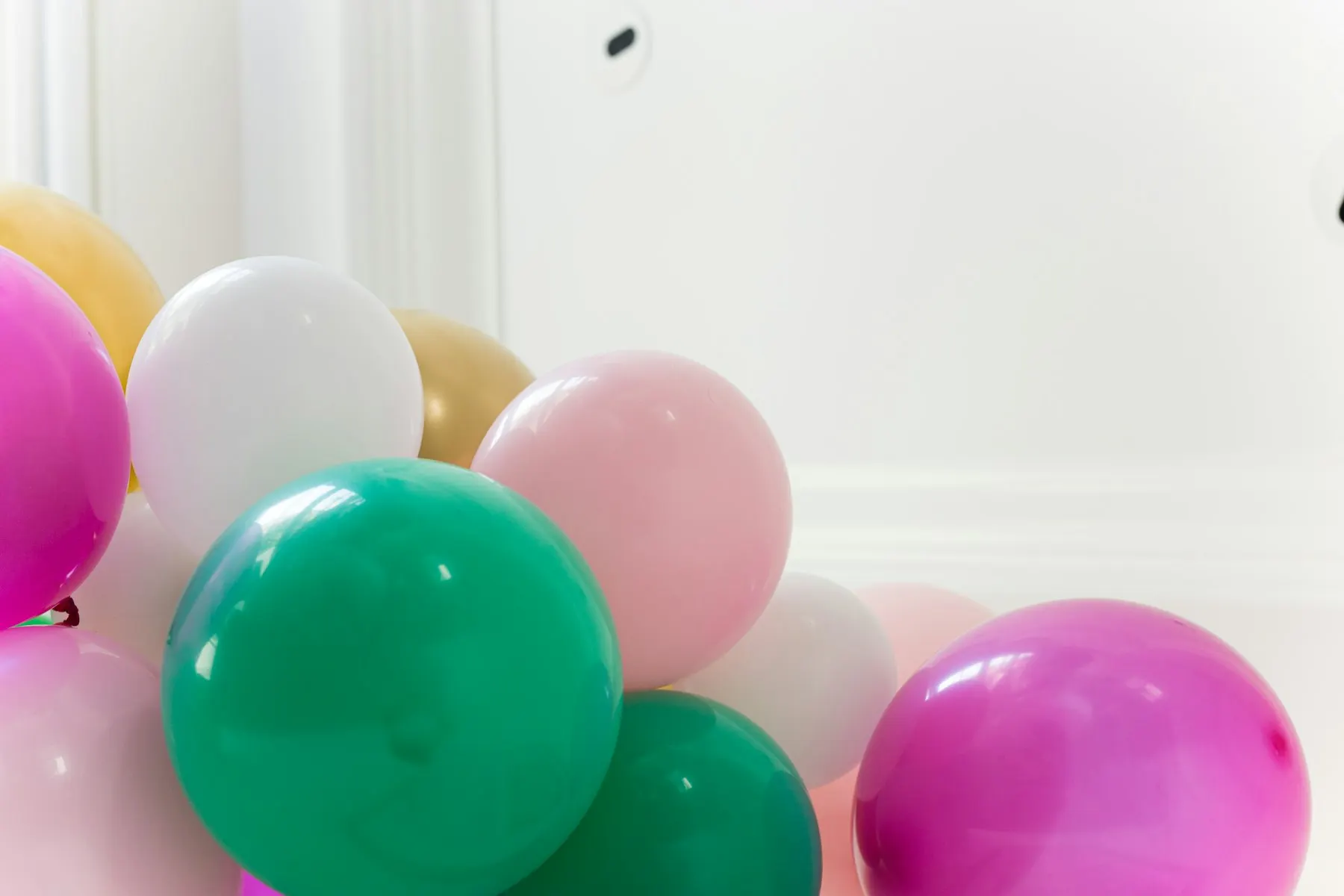 Purple and pink balloons on a white wall